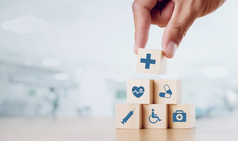 Main posant des cubes de bois avec dessins sur la santé