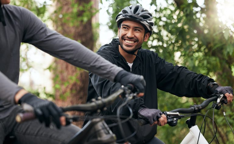 homme souriant sur un vélo avec un casque